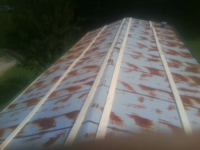 Rusted metal roof panels with new wood purlins before replacement — Storm Damage Roof Repair in Mc Farlan by Roofing Brothers