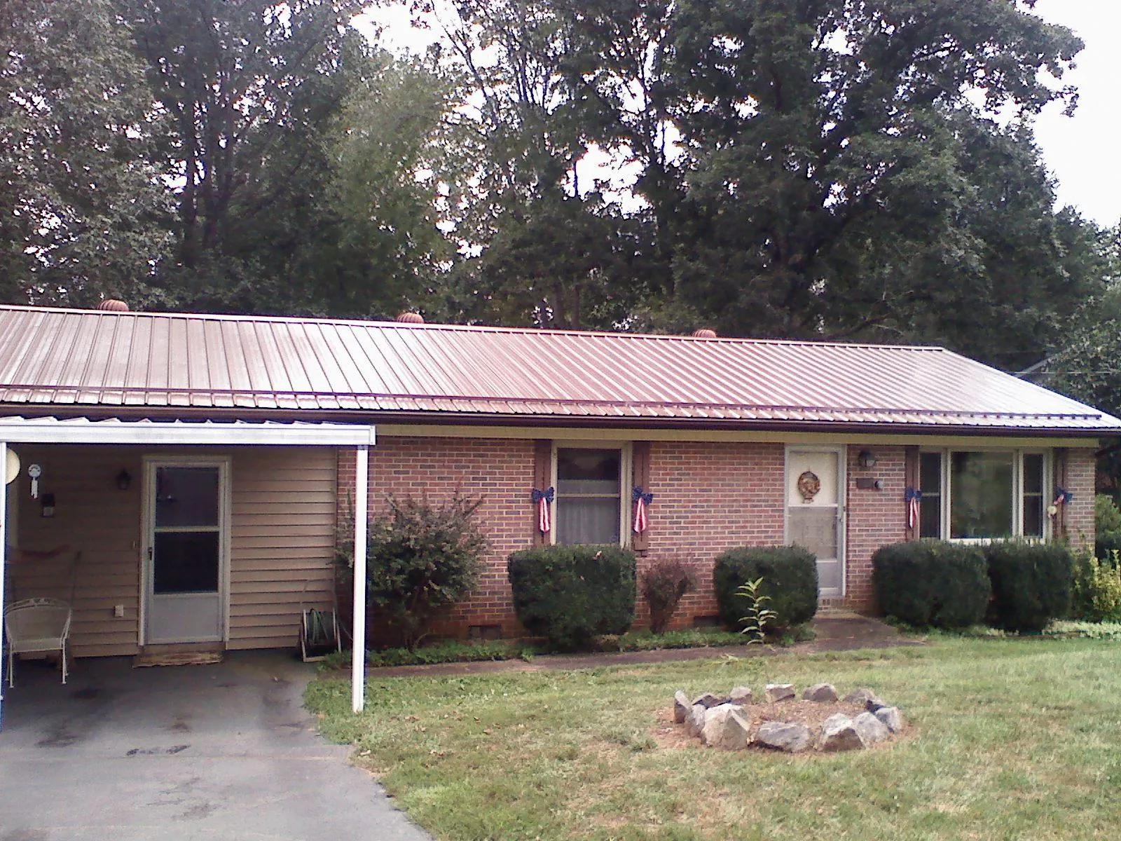 Bronze metal roof and carport on a brick ranch home — Roof Repair work by our crew in Mc Farlan